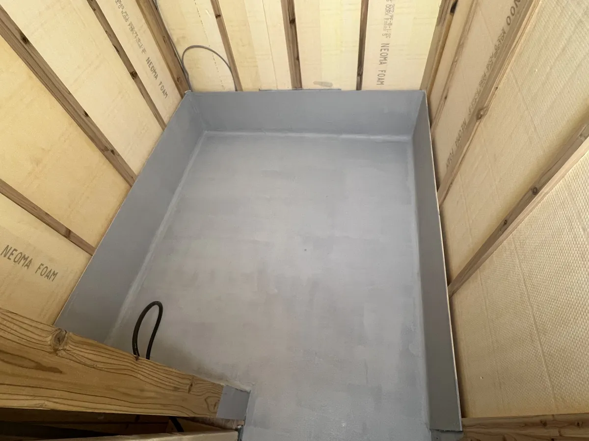 KUUTAサウナ施工風景：床から壁の立ち上がりまで、継ぎ目なく防水塗膜で包んだところ