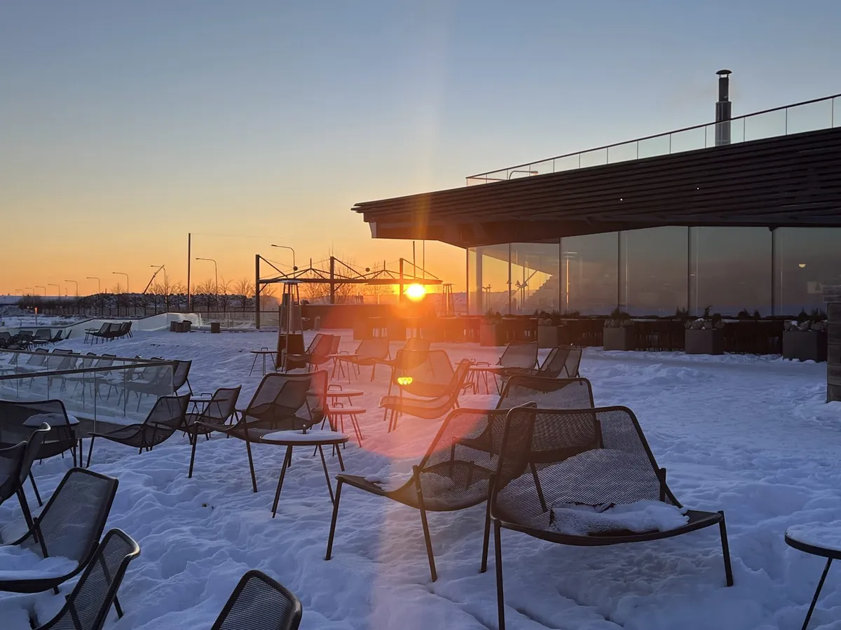 低い太陽に照らされた、雪をかぶったテラスの椅子
