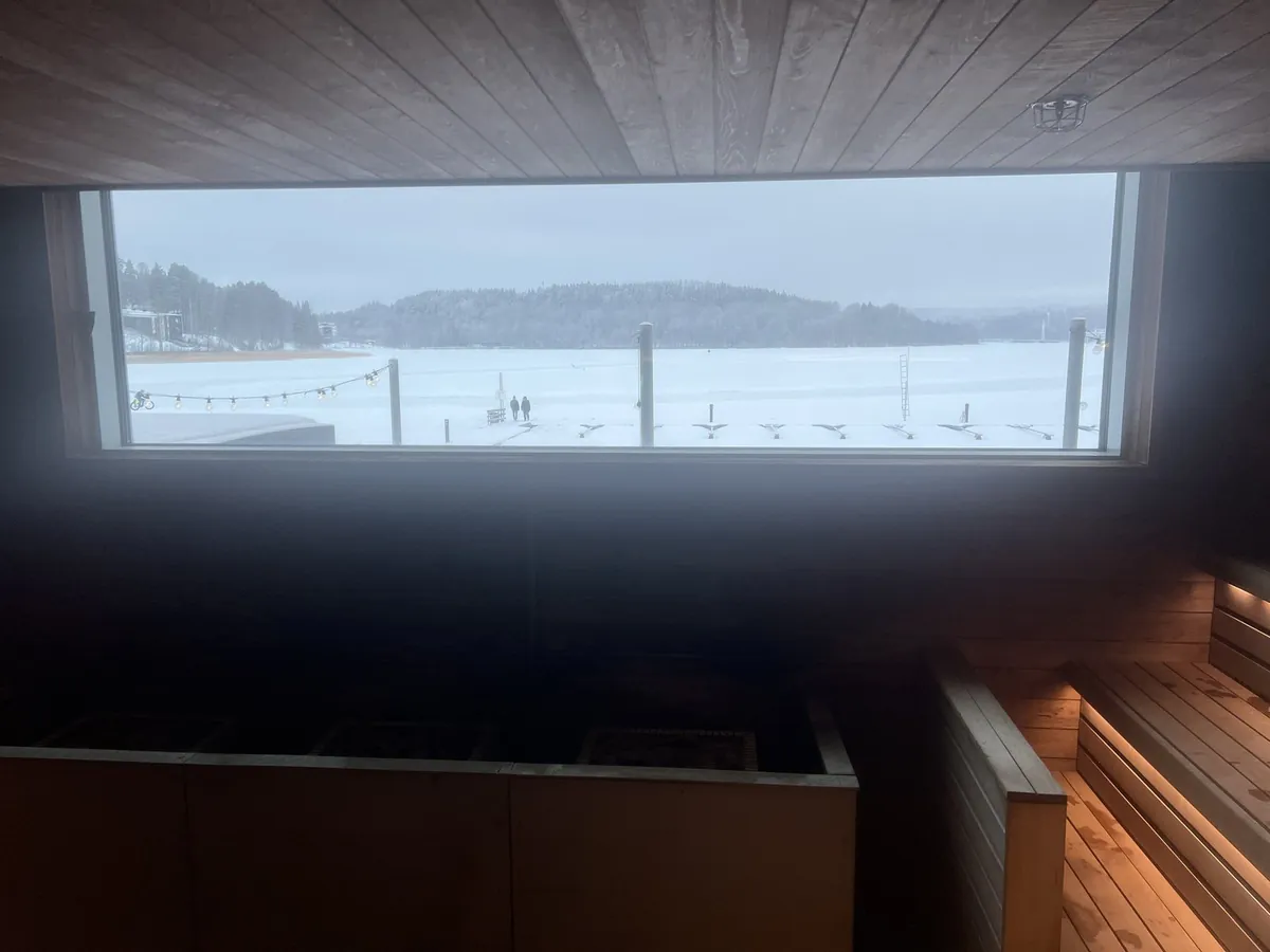 サウナ室の横長の窓から見える、雪に覆われた凍った湖