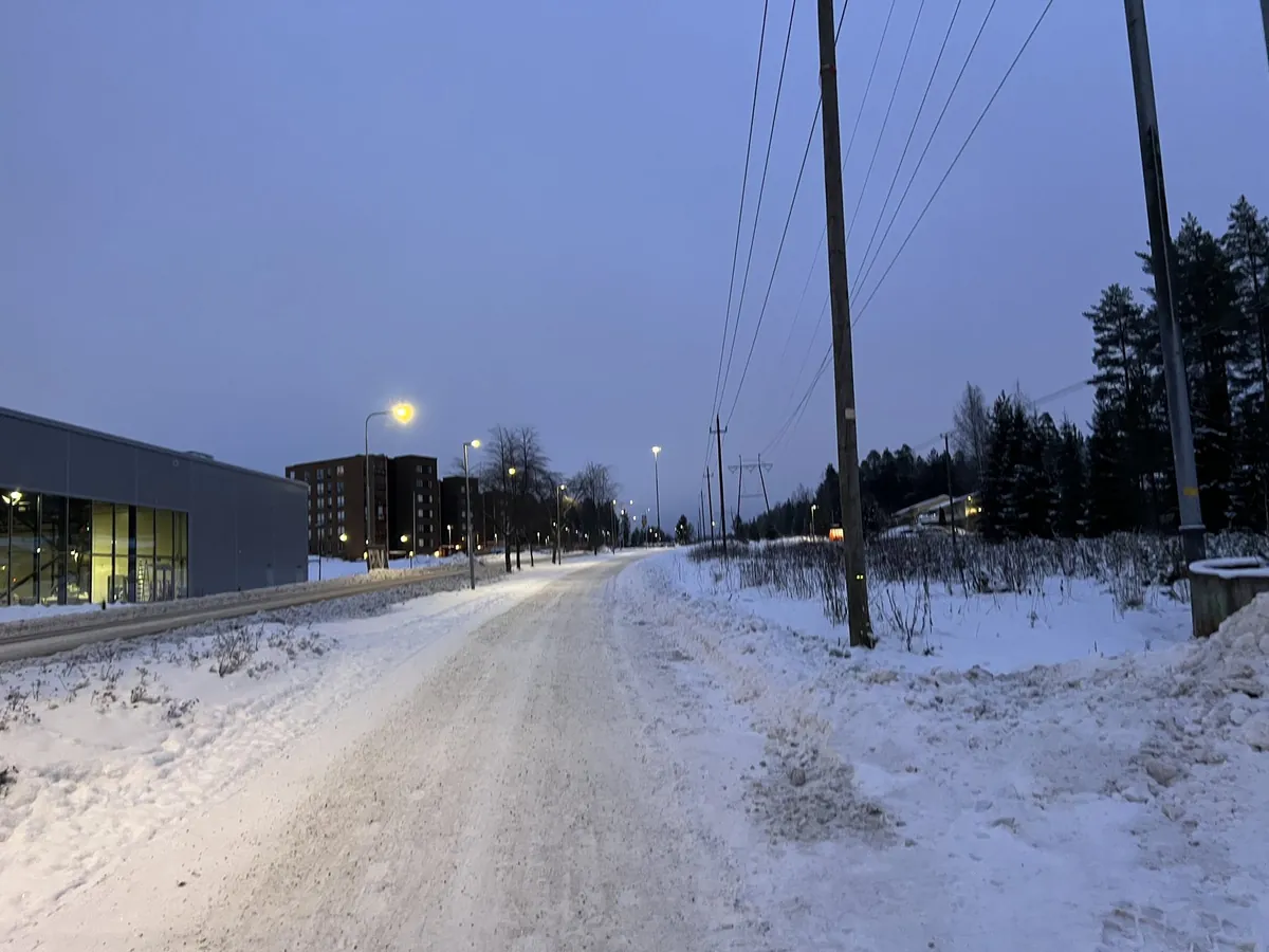 街灯が灯る薄暗い時間の、雪に覆われた道